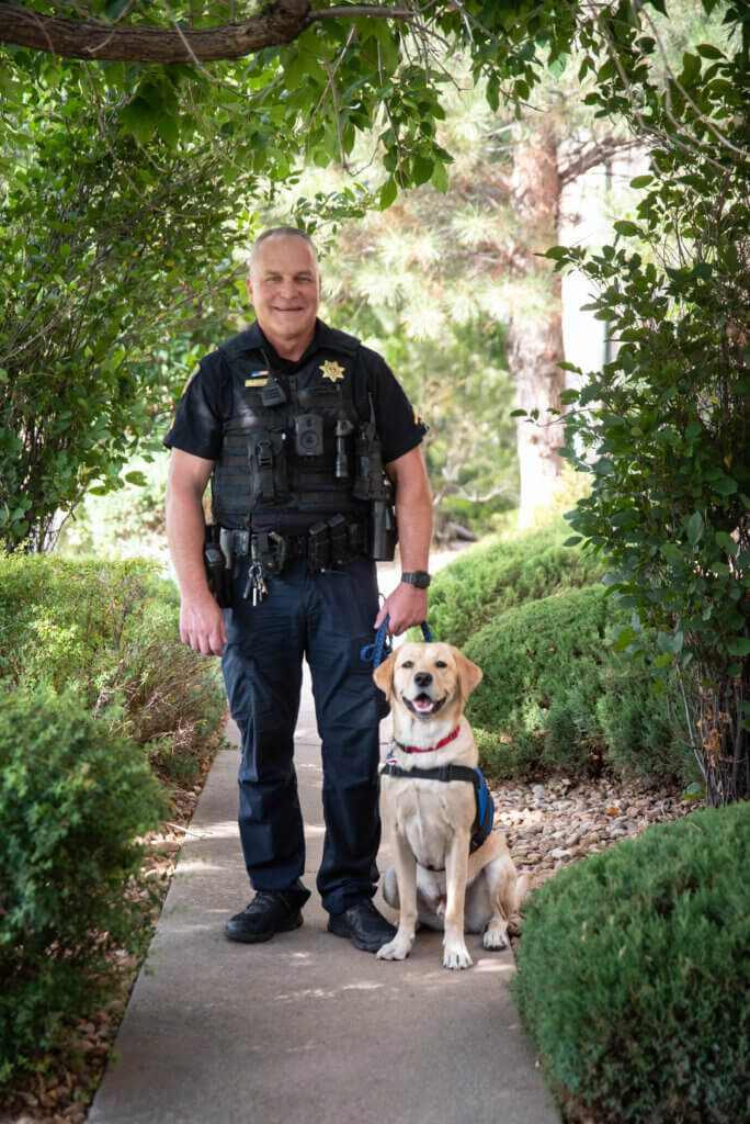 Colorado SRO Brian standing beside FSD Facility Dog Guster.